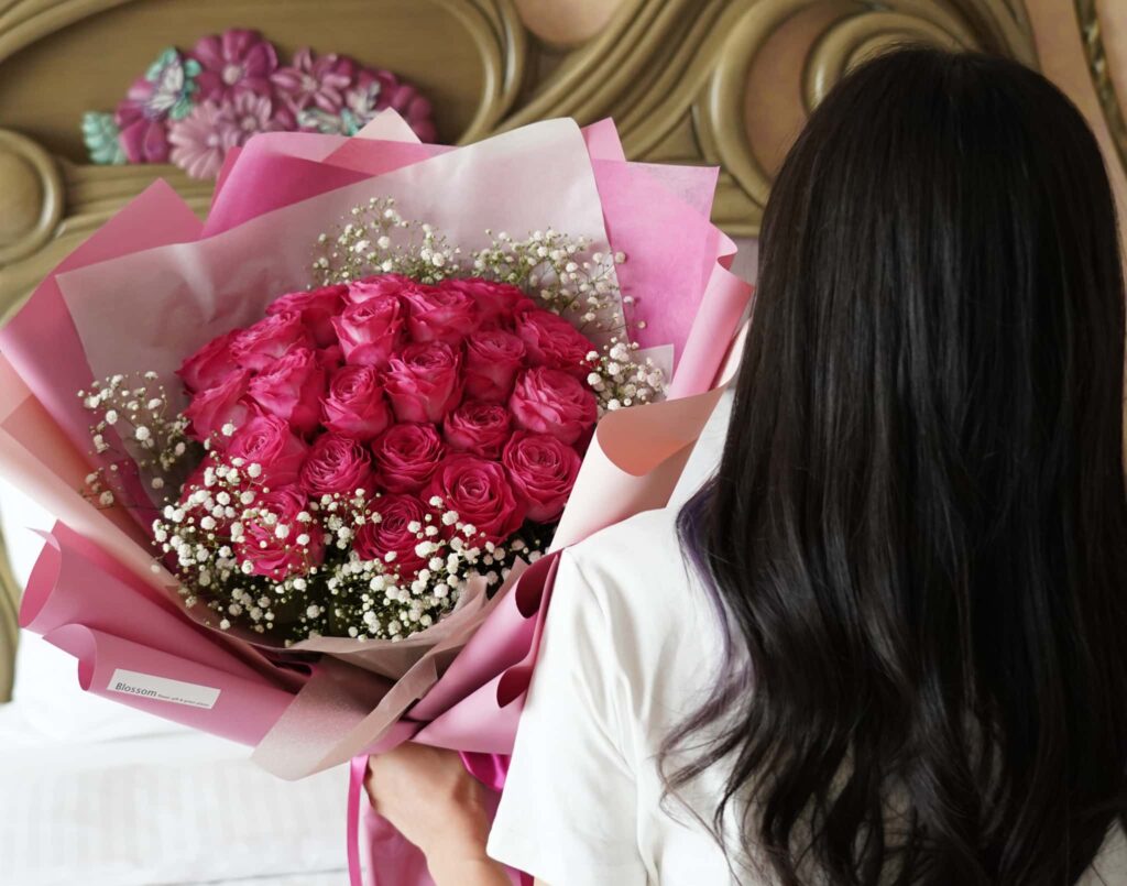 ピンクの薔薇とかすみ草をピンクの包装紙で包んだ花束