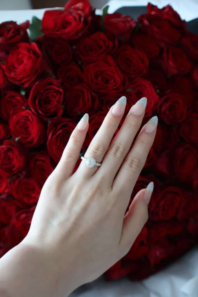 赤いバラの花束をバックにした婚約指輪