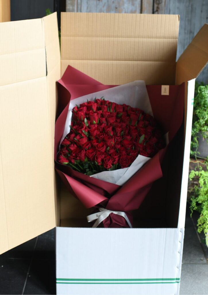 配送用の梱包箱に入った108本の赤い薔薇の花束
