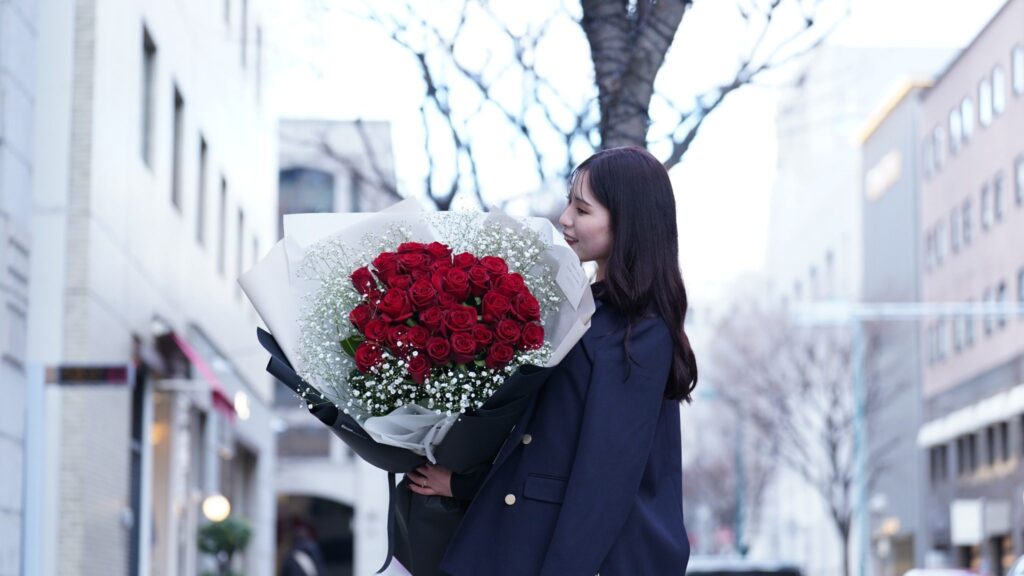 33本の赤い薔薇の花束を抱える女性と実際のサイズ感