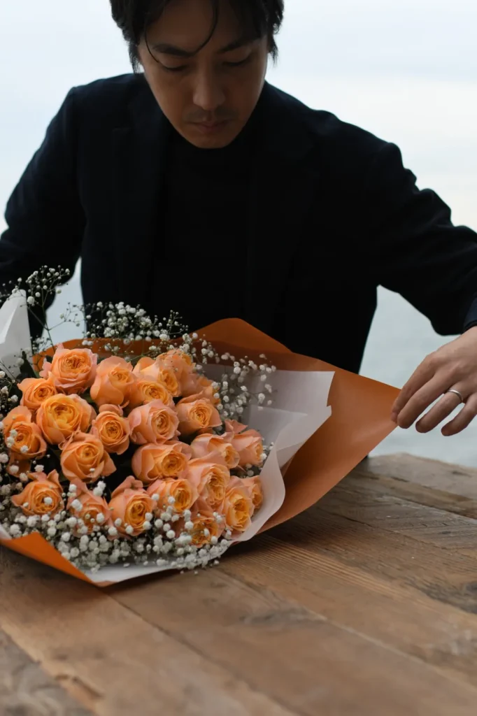 SolaVilla 海テラス南あわじでオレンジの薔薇を束ねる様子
