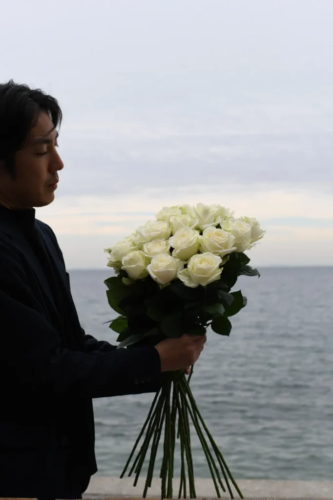 SolaVilla 海テラス南あわじで海を背景に束ねた白薔薇の花束